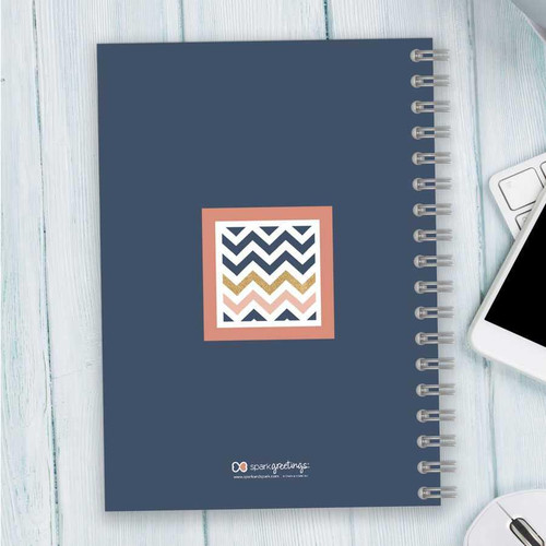 SparkGreetings® Blue Chevron Writing Journal, a navy blue spiral-bound notebook with a colorful chevron pattern on the cover.