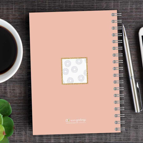 SparkGreetings® Spinning Circles Writing Journal, pink spiral-bound notebook with a decorative white square with gray circle patterns on the cover.