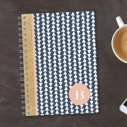 SparkGreetings® Triangles & Glitter Writing Journal, a navy blue and white triangle patterned journal with pink and gold glitter accents and a personalized initial B on the cover.