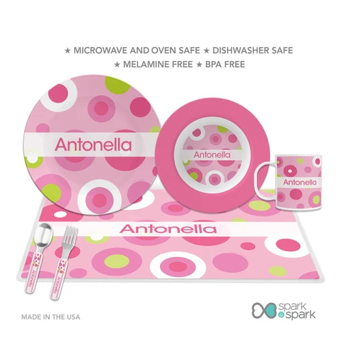 Spark & Spark Circles and Circles Pink Kids Bowl, colorful children's dinnerware set with pink, white, and green circles, featuring a large plate, smaller bowl, mug, fork, and spoon with matching designs, personalized with the name Antonella.