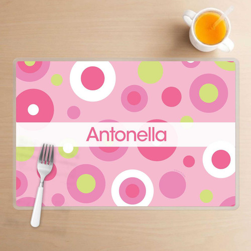 Spark & Spark Circles and Circles Pink Kids Placemat, personalized pink placemat with colorful circles and the name Antonella displayed in the center.