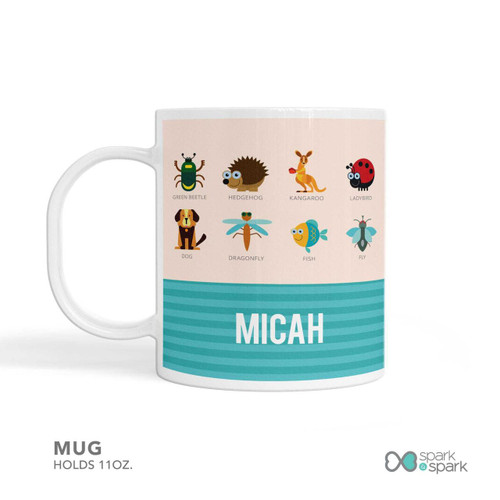 Spark & Spark Animal ABC Beige Kids Placemat mug featuring colorful animal illustrations including a green beetle, hedgehog, kangaroo, ladybird, dog, dragonfly, fish, and fly, with the name 'Micah' printed at the bottom.
