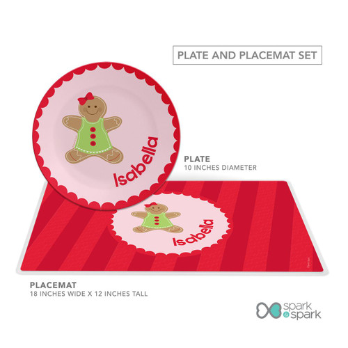 Spark & Spark Xmas Cookie Pink Kids Placemat, children's holiday-themed placemat with a gingerbread girl illustration and the name Isabella in red.