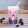 Spark & Spark Cute Gymnast Girl Toddler Cup, plastic cup with a gymnast girl climbing a ladder illustration on a pink and purple background, personalized with the name Elena, placed on a wooden surface with blackberries around.