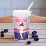 Spark & Spark Cute Gymnast Girl Toddler Cup, a colorful cup featuring a cartoon girl gymnast performing a balance beam act with the name Elena on it, placed on a wooden surface with blackberries surrounding it.