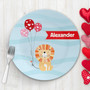 Spark & Spark Balloon Lion Kids Placemat with colorful balloons and a cartoon lion design, personalized with the name Alexander, on a light wooden surface with a fork and red heart-shaped decorations.