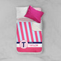 Spark & Spark Double Initial & Stripes Blue Sherpa Blanket, personalized pink and blue striped blanket with initials and name, on a bed with pillows.