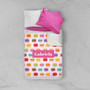 Spark & Spark Yummy Macaroons Sherpa Blanket, colorful macaroon pattern with a pink custom name label 'Gabriela' on the blanket, layered over white and pink pillows on a bed.