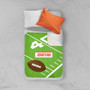 Spark & Spark Football Fan Sherpa Blanket, green and brown football-themed blanket with personalized name 'Jonathan' on a bed with white and orange pillows.