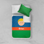 Spark & Spark Just Like Me Boy Blue Sherpa Blanket, blue and green blanket with a cartoon face and the name Brian printed on it, on a bed with white sheets and a green pillow.
