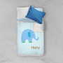Spark & Spark Blue Baby Elephant Sherpa Blanket, blue elephant design with green accents and personalized name Harry, on a bed alongside blue and white pillows.