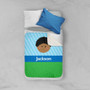 Spark & Spark Just Like Me Boy Lite Blue Sherpa Blanket, a child's bed with a personalized blanket featuring a cartoon boy's face, blue, green, and white colors, and the name Jackson printed on it.