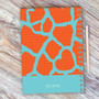 SparkGreetings® Cute Rocks Writing Journal, colorful abstract design with orange and blue pattern on a wooden surface with a pen.