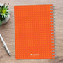 SparkGreetings® Mod Chevrons Writing Journal, orange cover with yellow chevron dots and spiral binding on the right side.