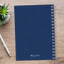 SparkGreetings® Mod Chevrons Writing Journal, blue notebook with chevron pattern and spiral binding on wooden surface.