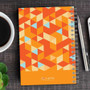 SparkGreetings® Dynamic Ways Writing Journal, orange geometric patterned notebook on a desk.