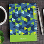SparkGreetings® Dynamic Ways Writing Journal, colorful geometric patterned journal on wooden desk with pen, coffee cup, and smartphone.