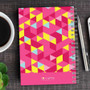 SparkGreetings® Dynamic Ways Writing Journal, colorful geometric pattern with pink, yellow, blue, and light pink triangles on the cover.
