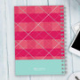 SparkGreetings® Criss Cross Writing Journal, pink and red plaid design with white criss-cross lines and a light blue bottom section.
