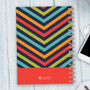 SparkGreetings® Style in Stripes Writing Journal, vibrant multicolored striped design with spiral binding on white wooden surface.