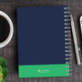 SparkGreetings® Urban Graffiti Writing Journal, navy blue cover with green accent, spiral-bound notebook on a wooden desk with a coffee cup, pen, and a smartphone.