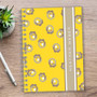 SparkGreetings® Small Swirls Writing Journal, a yellow spiral-bound journal with a floral swirl pattern and the name Heather Weber on the cover placed on a wooden desk with a pen and a potted succulent plant.