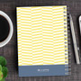 SparkGreetings® Up and Down Style Writing Journal, yellow and white chevron pattern notebook with spiral binding on a wooden desk with a cup of coffee, pen, and smartphone.
