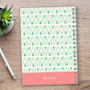 SparkGreetings® Tribal Mood Writing Journal, geometric tribal pattern in teal and pink with silver spiral binding on wooden desk with a silver pen and green succulent plant.
