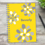 SparkGreetings® Stamped Blossoms Writing Journal, personalized yellow notebook with white and gray flower designs and the name Beverly on the cover.