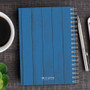 SparkGreetings® Rustic Anchor Writing Journal, blue rustic wood cover with spiral binding and silver pen on desk.