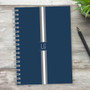 SparkGreetings® Elegant Ribbon Writing Journal, navy blue cover with white and gray ribbon design, spiral-bound notebook on rustic wooden surface with a black pen and green plant.