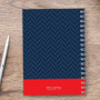 SparkGreetings® Small Anchor Writing Journal, navy blue geometric pattern cover with red band and silver spiral binding on wooden surface with white pen.