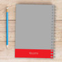 SparkGreetings® Bike Ride Writing Journal, gray and red spiral-bound notebook with a blue pencil on a wooden surface.