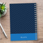 SparkGreetings® Nautical Anchor Writing Journal, navy blue cover with a chevron pattern and a solid blue band at the bottom featuring the SparkGreetings logo, on a wooden desk with a silver pen and a small potted succulent plant.
