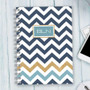 SparkGreetings® Blue Chevron Writing Journal, spiral-bound notebook with navy, gold, and blue chevron pattern cover and monogram 'BLN' on the front.