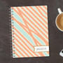 SparkGreetings® Tapestry Pattern Writing Journal, personalized journal with a pastel orange and blue striped pattern and the name Jessica on a label with a gold border.
