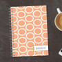 SparkGreetings® Tapestry Pattern Writing Journal, printed with an orange and white circle pattern on the cover, personalized with the name Jessica.