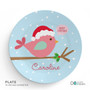 Spark & Spark Cute Xmas Birdie Kids Placemat, a round light blue placemat featuring a pink bird wearing a Santa hat, with a speech bubble saying 'Merry Christmas', holly leaves with red berries, a branch, and the name 'Caroline' in pink cursive.