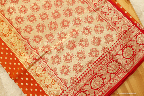 An orange-red silk saree with golden zari for timeless traditions