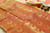 Grand red and golden zari silk saree with a green pallu embellished with zari