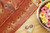 Grand red and golden zari silk saree with a green pallu embellished with zari