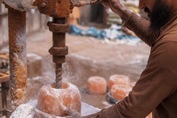 Artisan drilling a cavity into a salt block