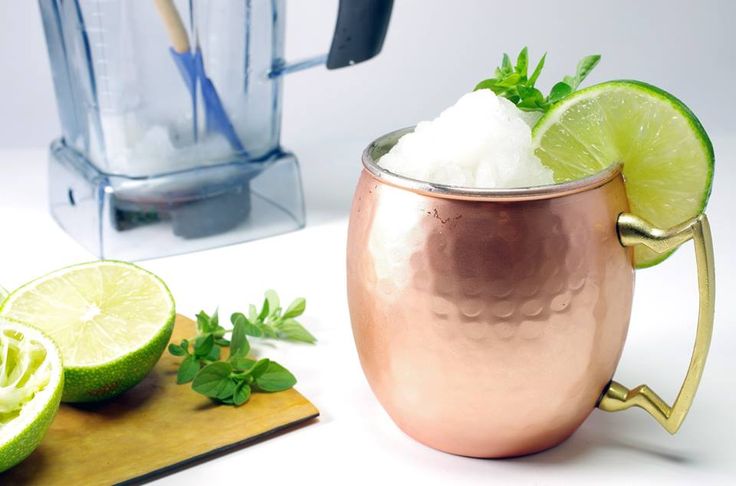 Bartender making and serving sweating copper mule mugs