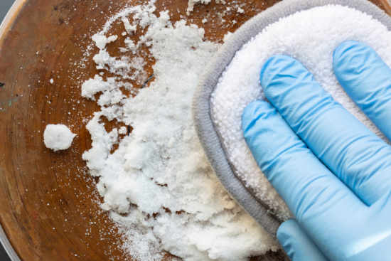 Lemon and salt being used to clean a copper pot