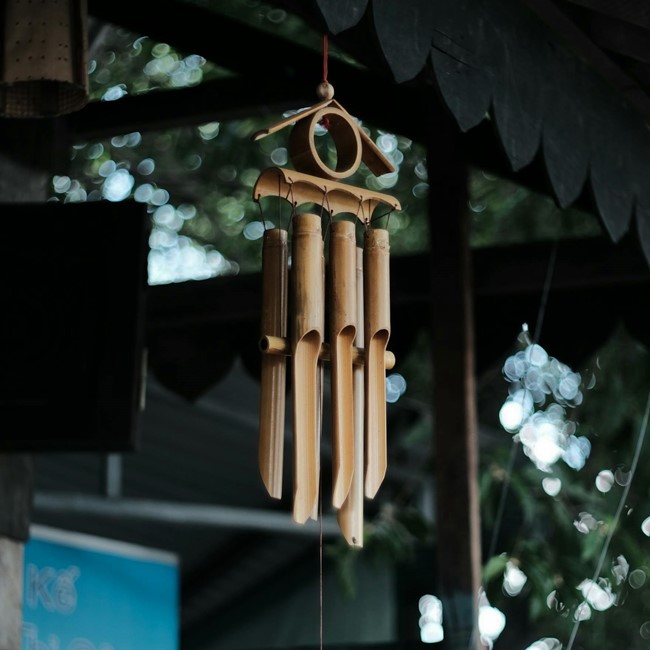 Bamboo wind chimes hanging from porch awning
