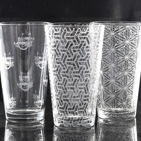 Three pint glasses with custom engraved designs