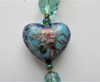 A cloisonne heart bead (center) represents the love of the Prince and Rusalka.