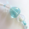 Delicate glass heart beads further indicate the themes of love and compassion.