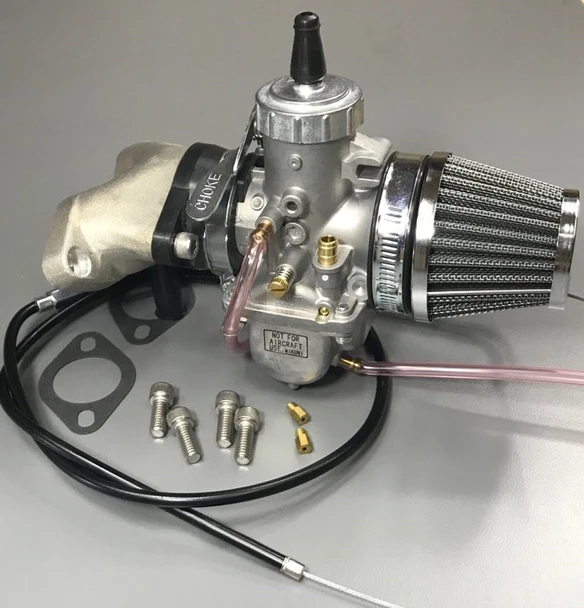 Upgrade your Norton Commando with a Genuine Mikuni VM34 single carburetor conversion kit. Features an upgraded alloy 2-into-1 intake manifold, nylon-lined throttle cable, pod air filter, and tuning jets for improved starting, smoother idle, better throttle response, acceleration, and reliable performance.
