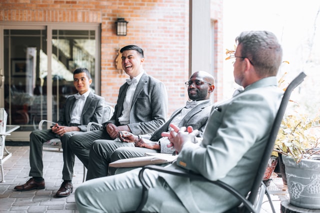 Four groomsmen sitting outside